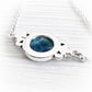 Back of a sterling silver memorial pendant hallmarked .925 with a blue hand blown glass cabochon