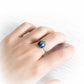 Dainty minimalist memorial ring with cremation ashes swirled in colorful hand blown glass on a models hand