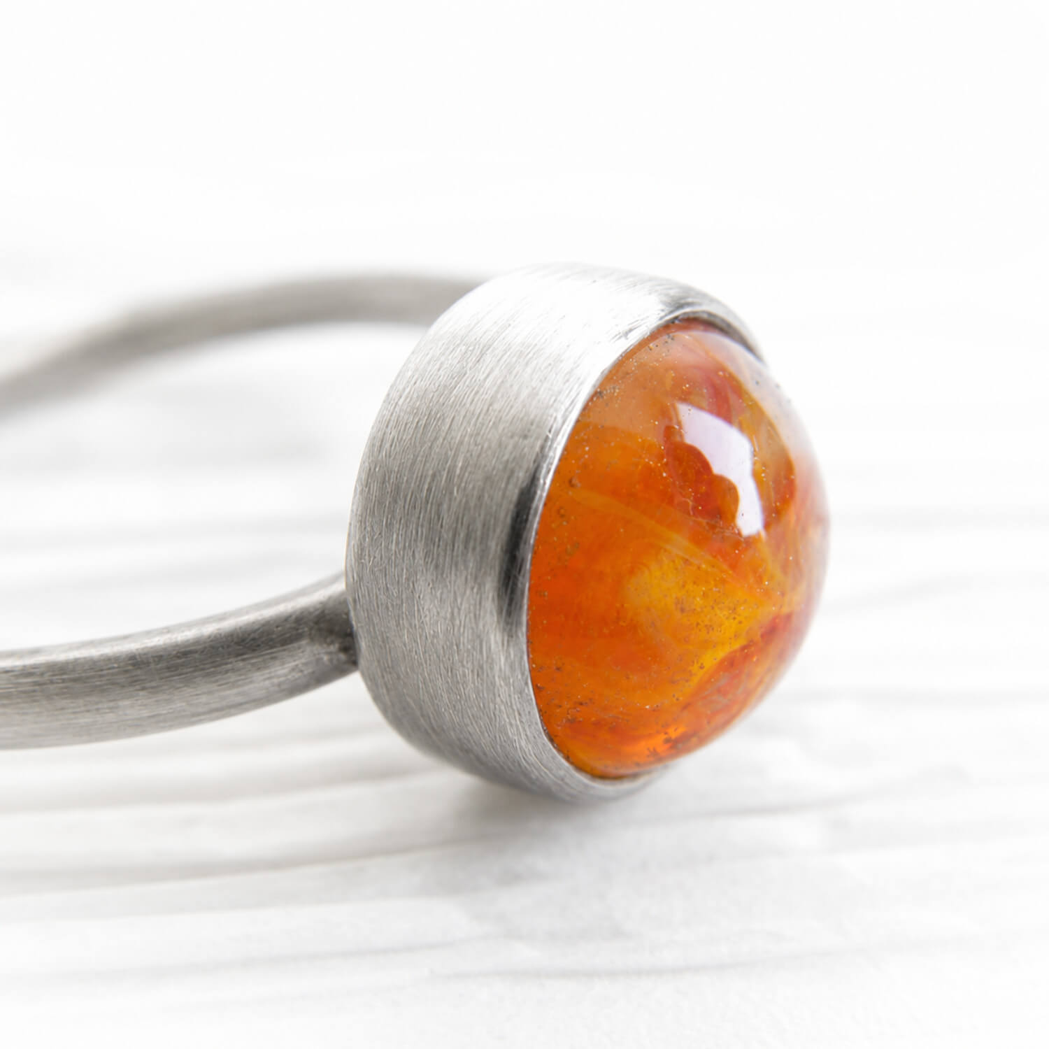Orange hand blown glass made with pet ashes set in a sterling silver memorial ring with an antique finish 