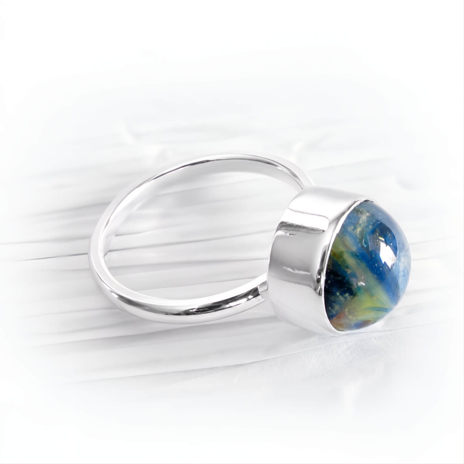 Ashes suspended within blue and green hand blown glass set in a sterling silver memorial ring