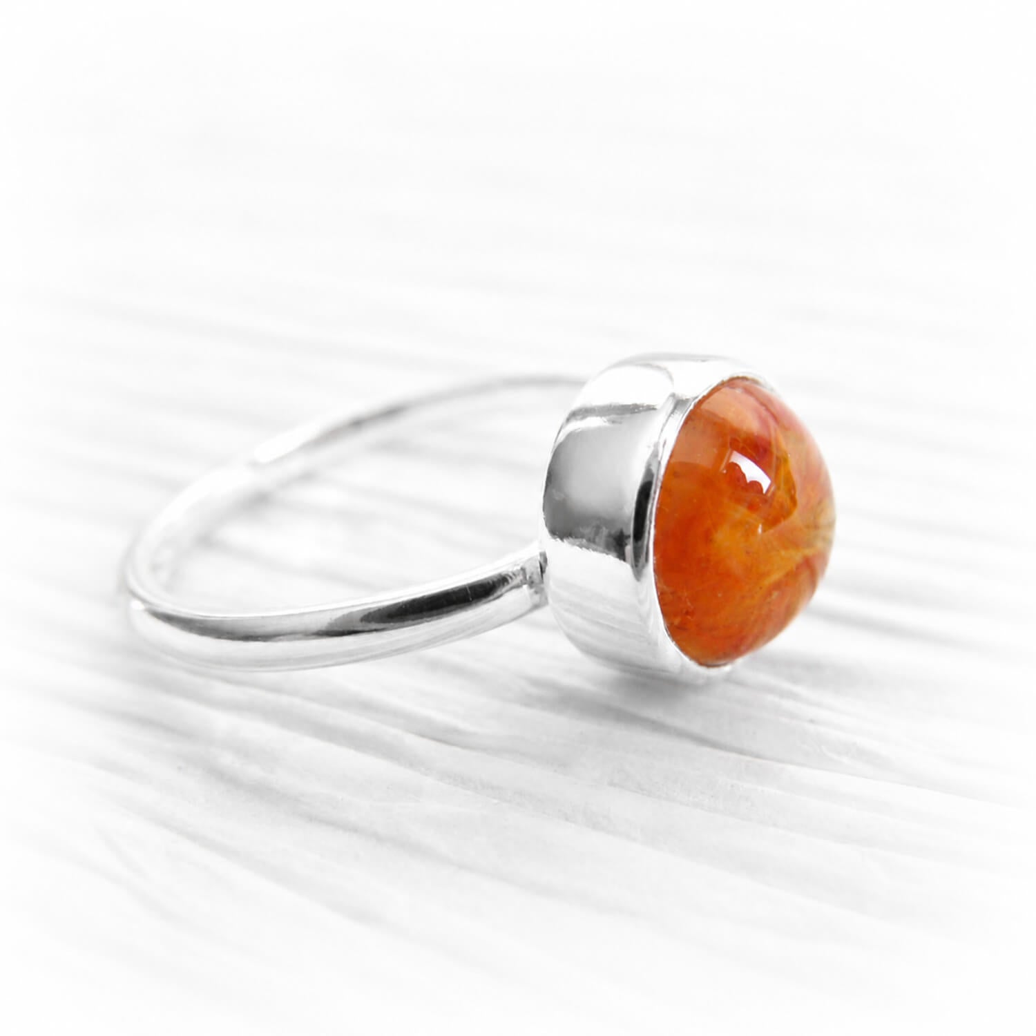Orange hand blown glass encasing cremation ashes set into a polished sterling silver memorial ring