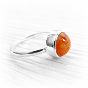 Orange hand blown glass encasing cremation ashes set into a polished sterling silver memorial ring