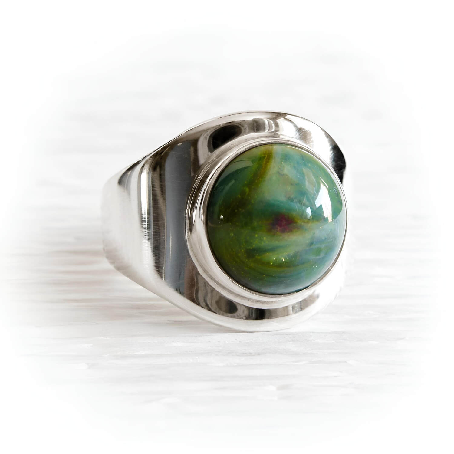 Colorful glass cremation gem stone containing pet ashes set in a sterling silver memorial ring