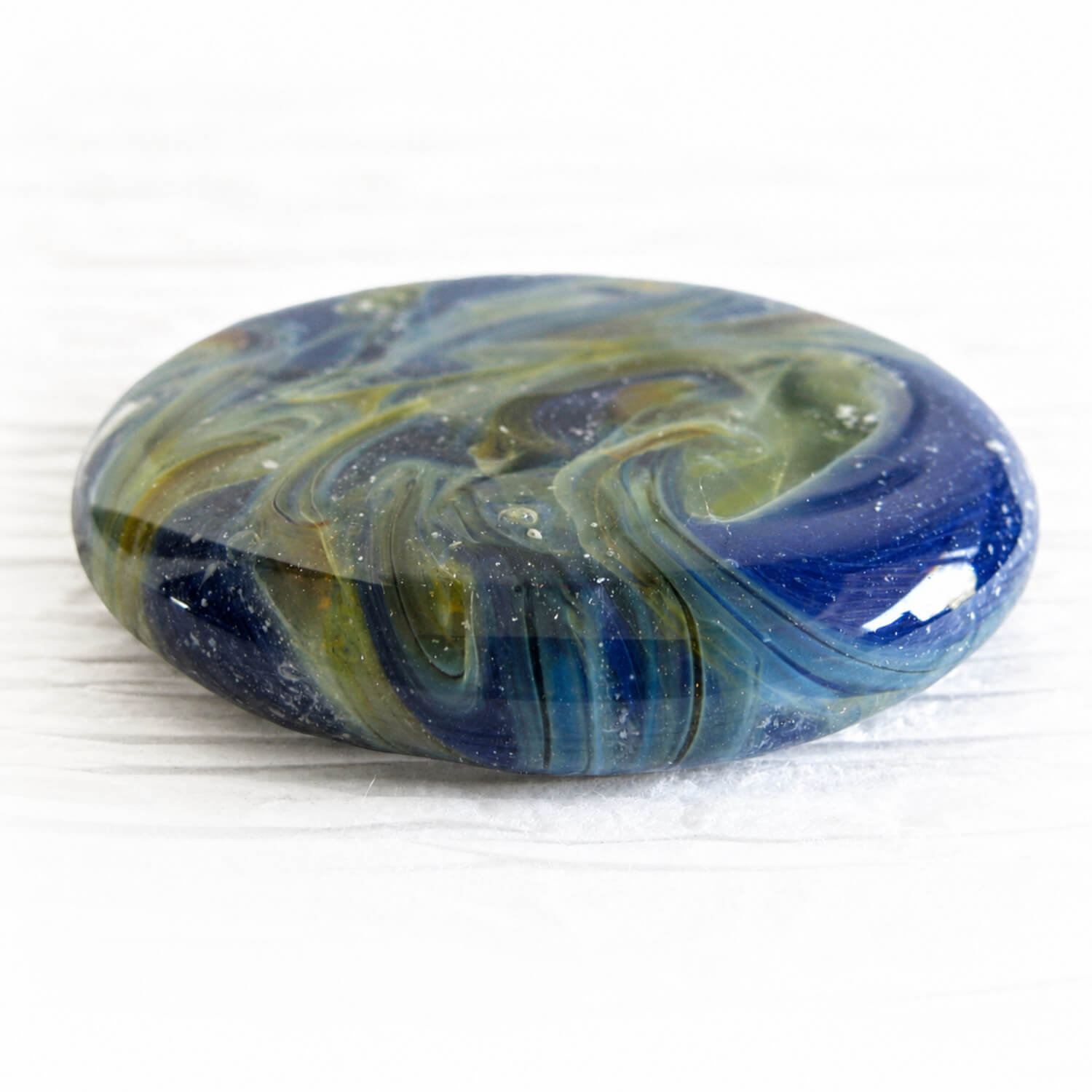 Hand blown glass memory stone artisan crafted with swirls of blue glass, green glass and cremation ashes
