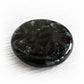 Swirls of cremation ashes and black hand blown glass shaped as a round memory stone