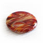 Red and orange hand blown glass swirled with pet ashes shaped into a round cremation memory stone