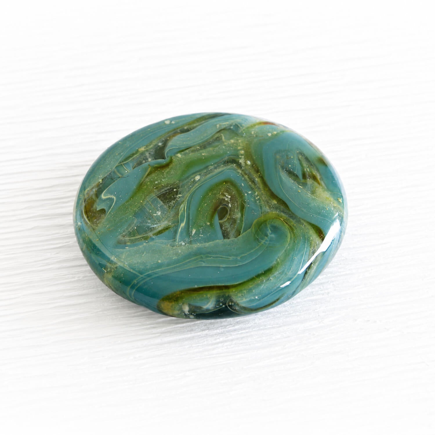 Handcrafted aqua and green glass memory stone keepsake incorporating ashes