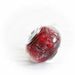Hand blown red glass bead with sterling silver bead caps on a white backround