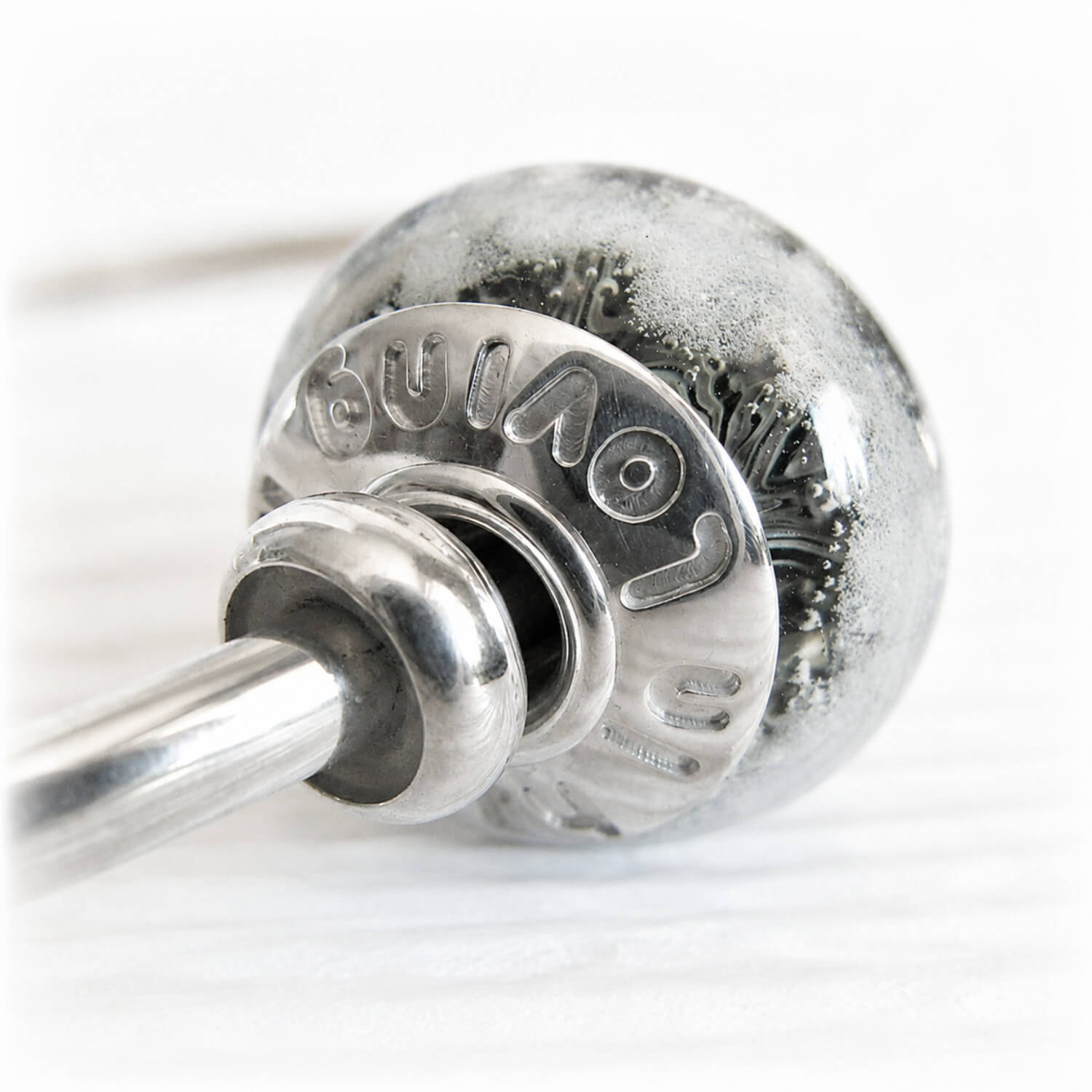 Custom engraving on a sterling silver bead cap set on a glass bead containing cremation ashes