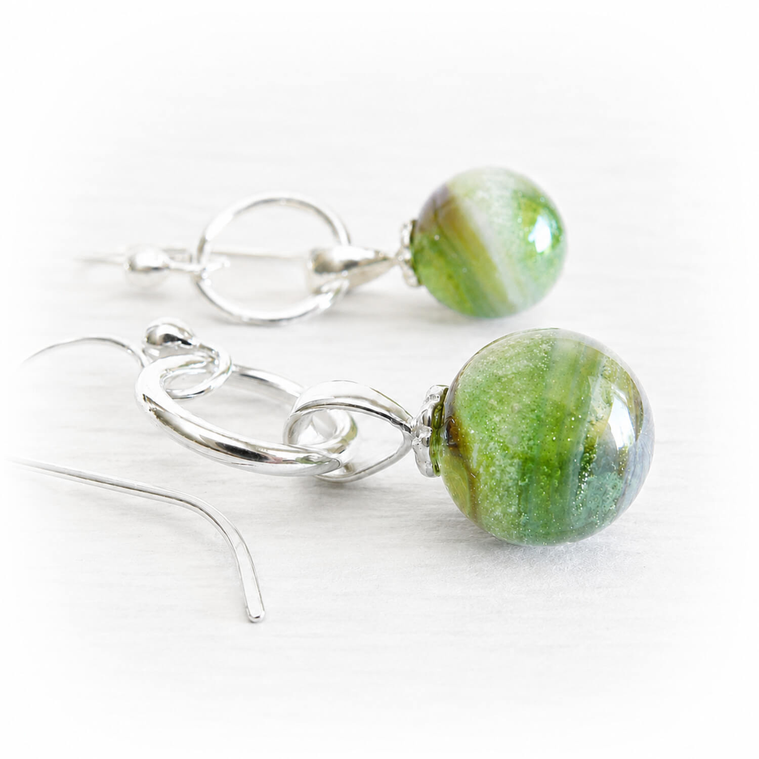 Green marbled hand blown glass bead earrings with swirls of cremation ashes on sterling silver hooks