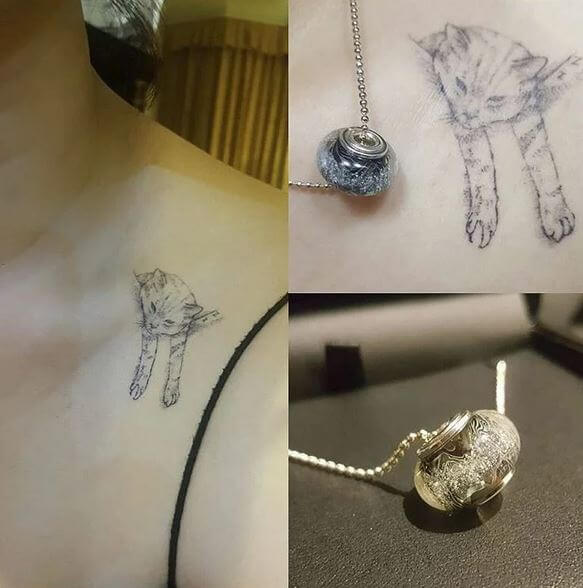 Silver pendant resembling a cat on a chain, with a tattoo of a cat on skin.