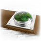 Brown leather memorial cuff bracelet with ashes suspended within swirls of hand blown green glass mounted in sterling silver