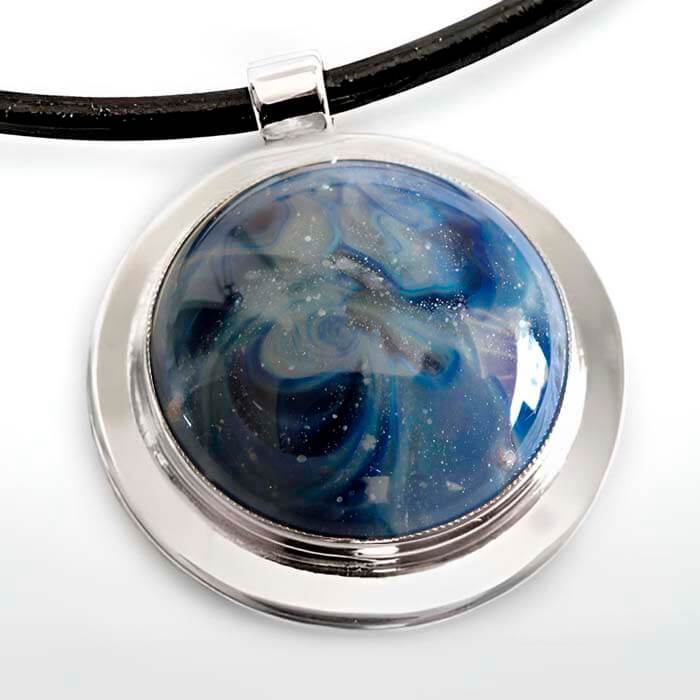 Necklace with a round glass pendant featuring blue and white cremation ash marbled design on a white background