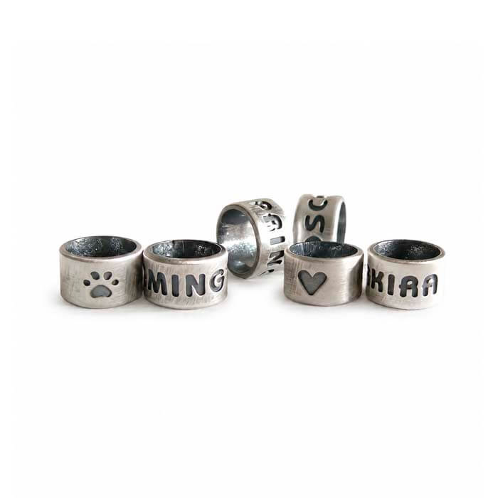 Antique finished sterling silver slider beads with custom engraving on a white background 