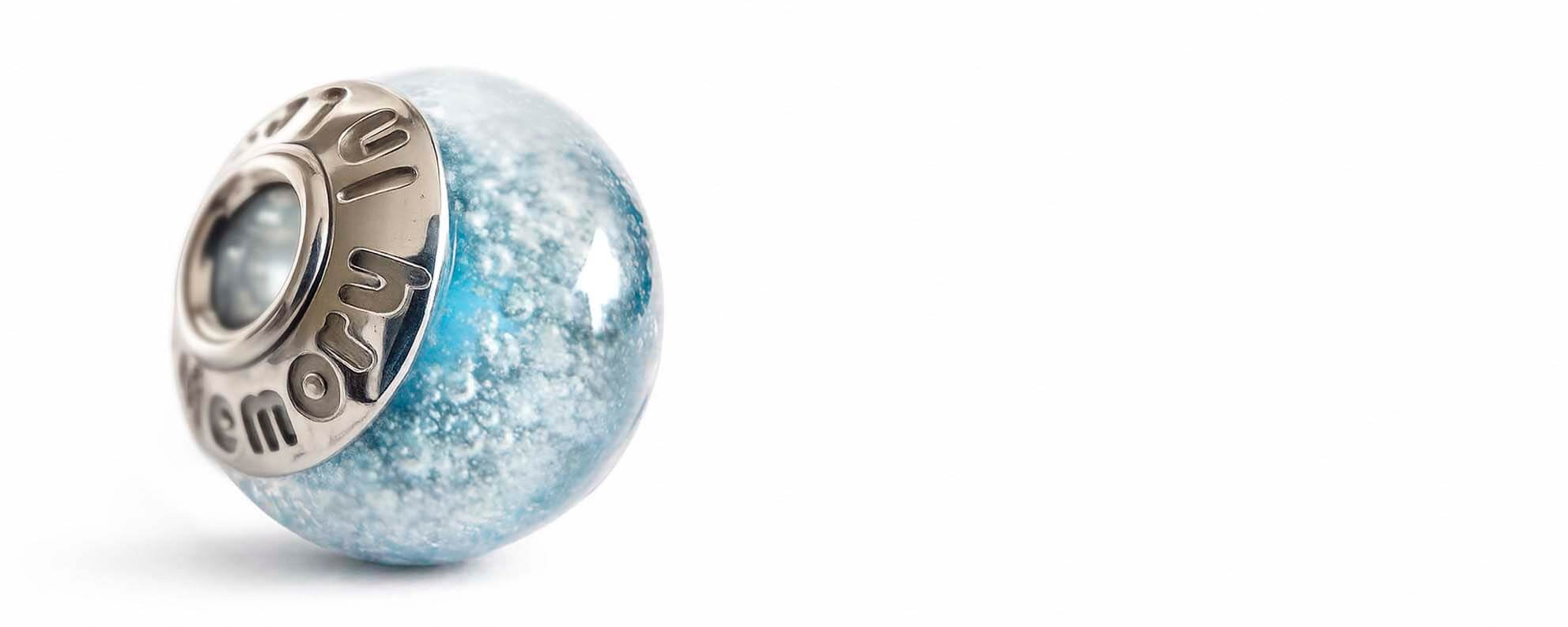 Memorial bead containing cremation ashes within handcrafted blue glass and polished sterling silver bead caps