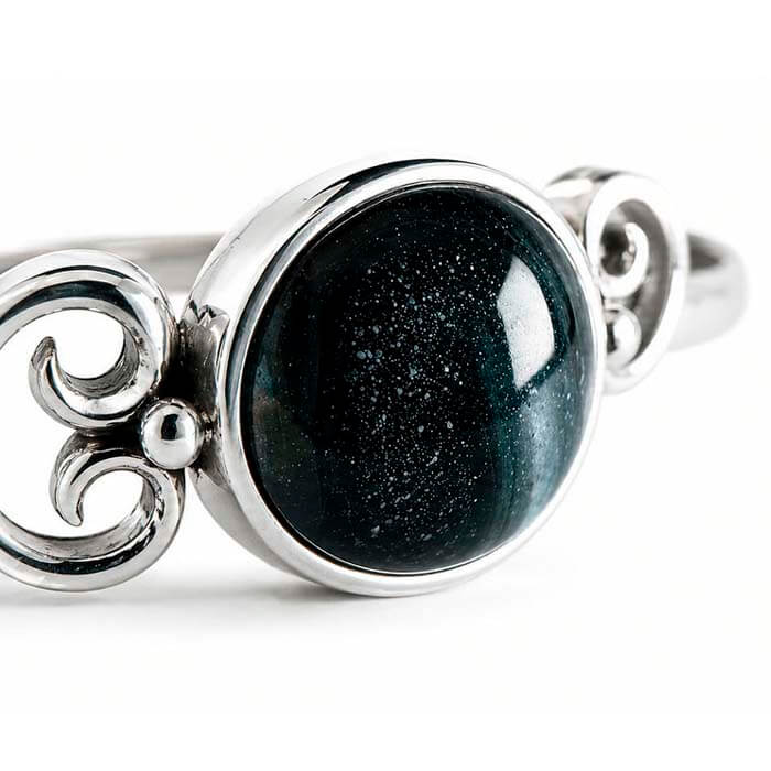 Silver ring with a black cremation ash glass cabochon 
on a white background