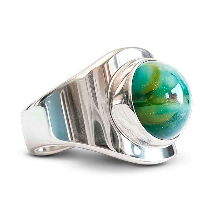 Silver ring with a cremation ash glass cabochon green and aqua on a white background