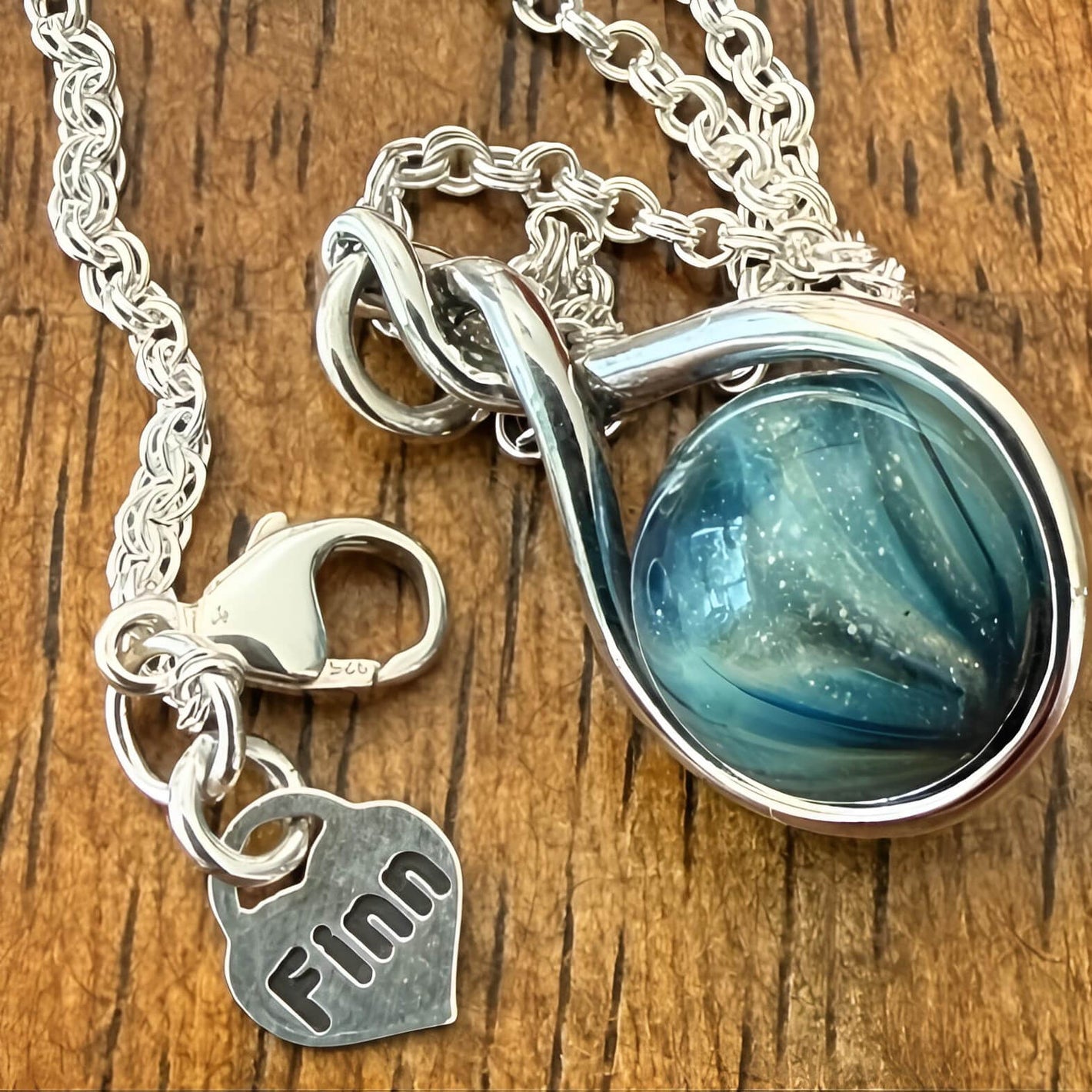 Hand blown pet memorial necklace with sterling silver chain and custom engraved 'Finn' charm