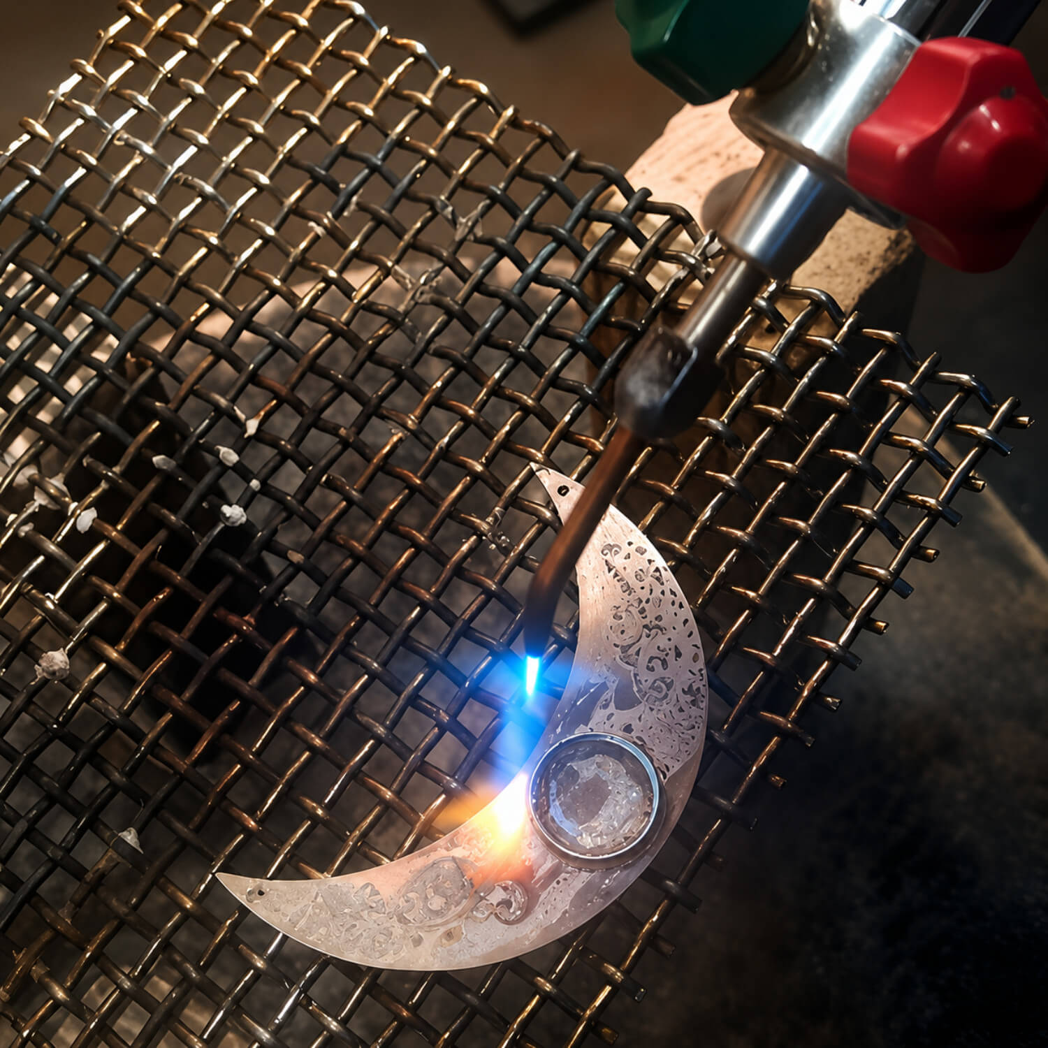 Metalworking process with a metal object being heated by a flame on a grid surface.