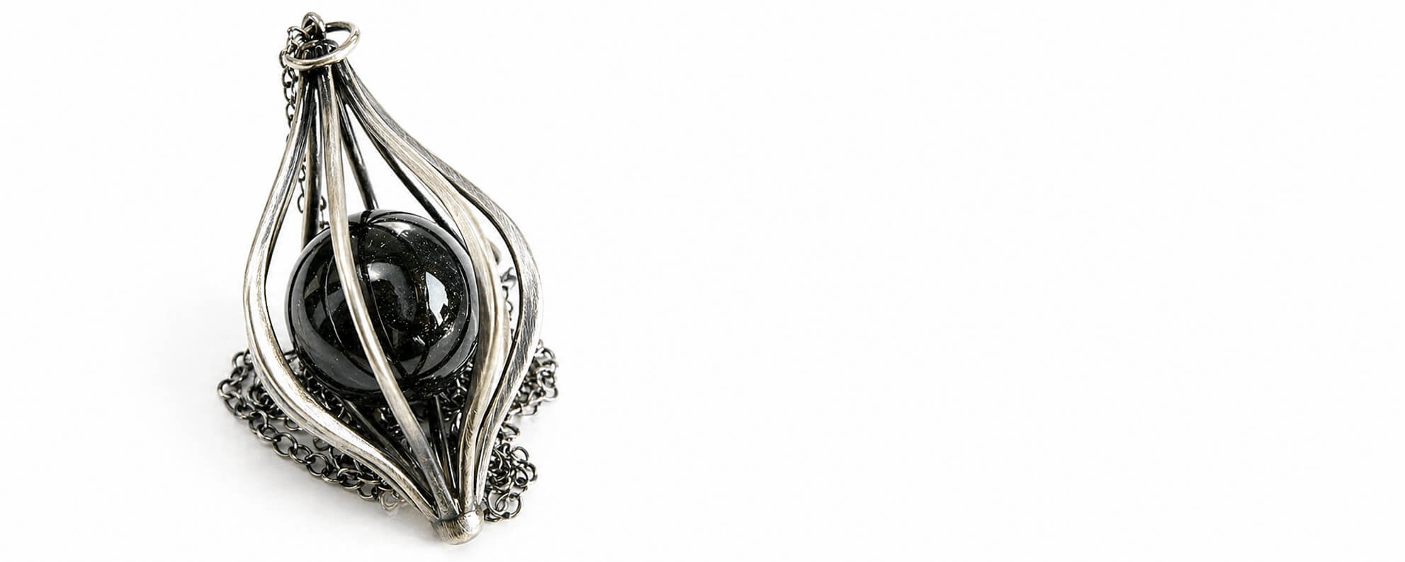 Decorative black and silver pendant on a white background