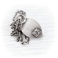 A silver-toned pendant necklace featuring a brushed metal teardrop-shaped tag with a small square engraving that reads '925', attached to a layered chain with a twisted rope link and a curb link, displayed on a light wood background.