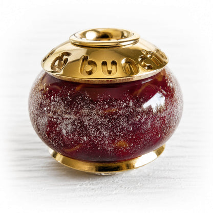 Cremation ashes encased over deep red hand blown glass set with custom engraved solid 14k gold bead caps