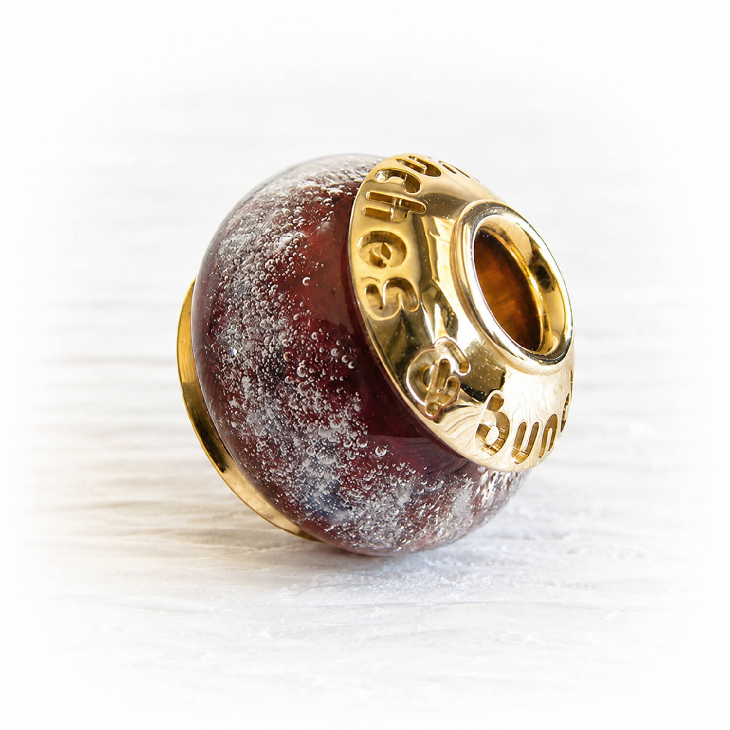 Dark red glass bead containing pet ashes with custom engraved 14k gold bead caps