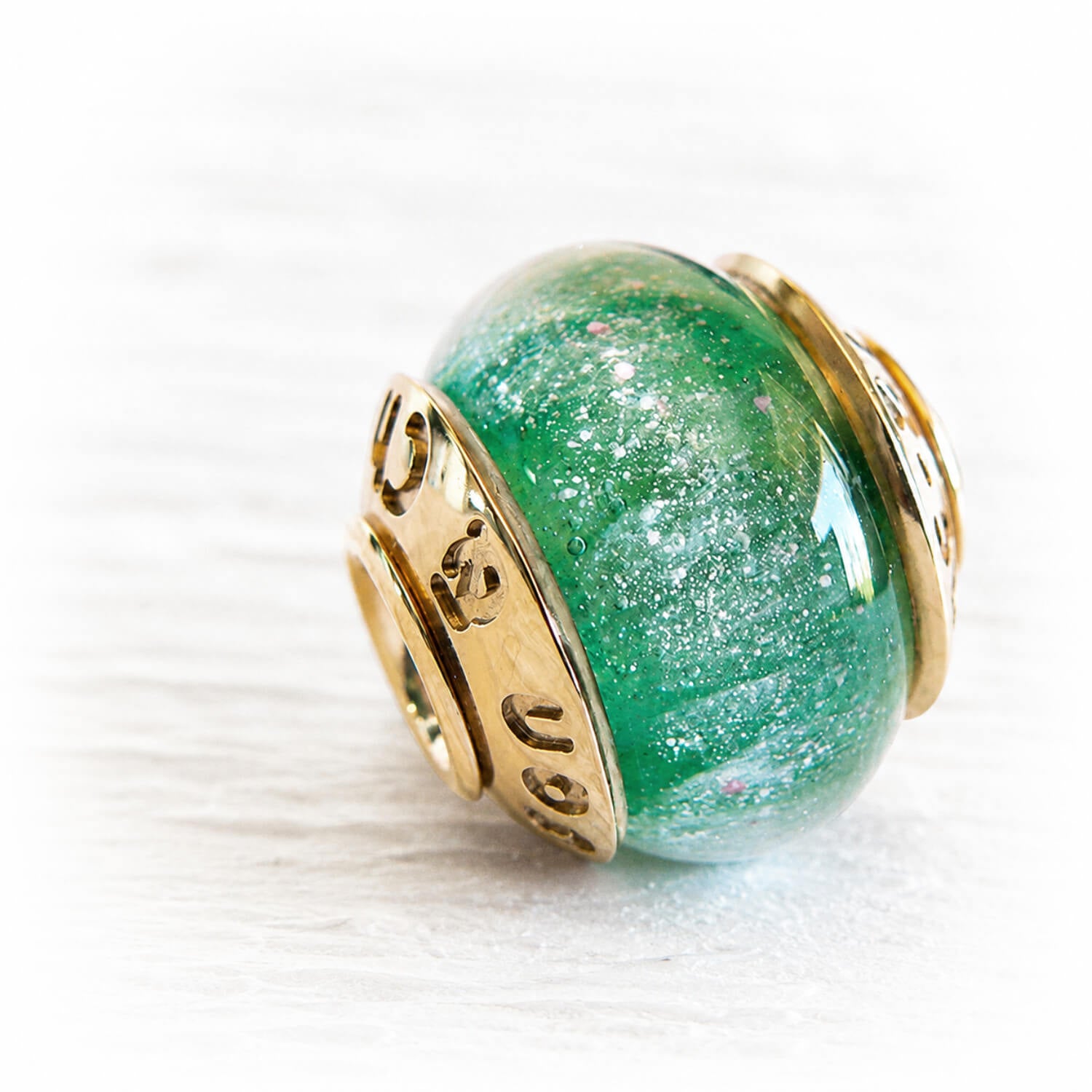 Sparkling green glass bead with white cremation ashes set with 14k gold custom engraved bead caps