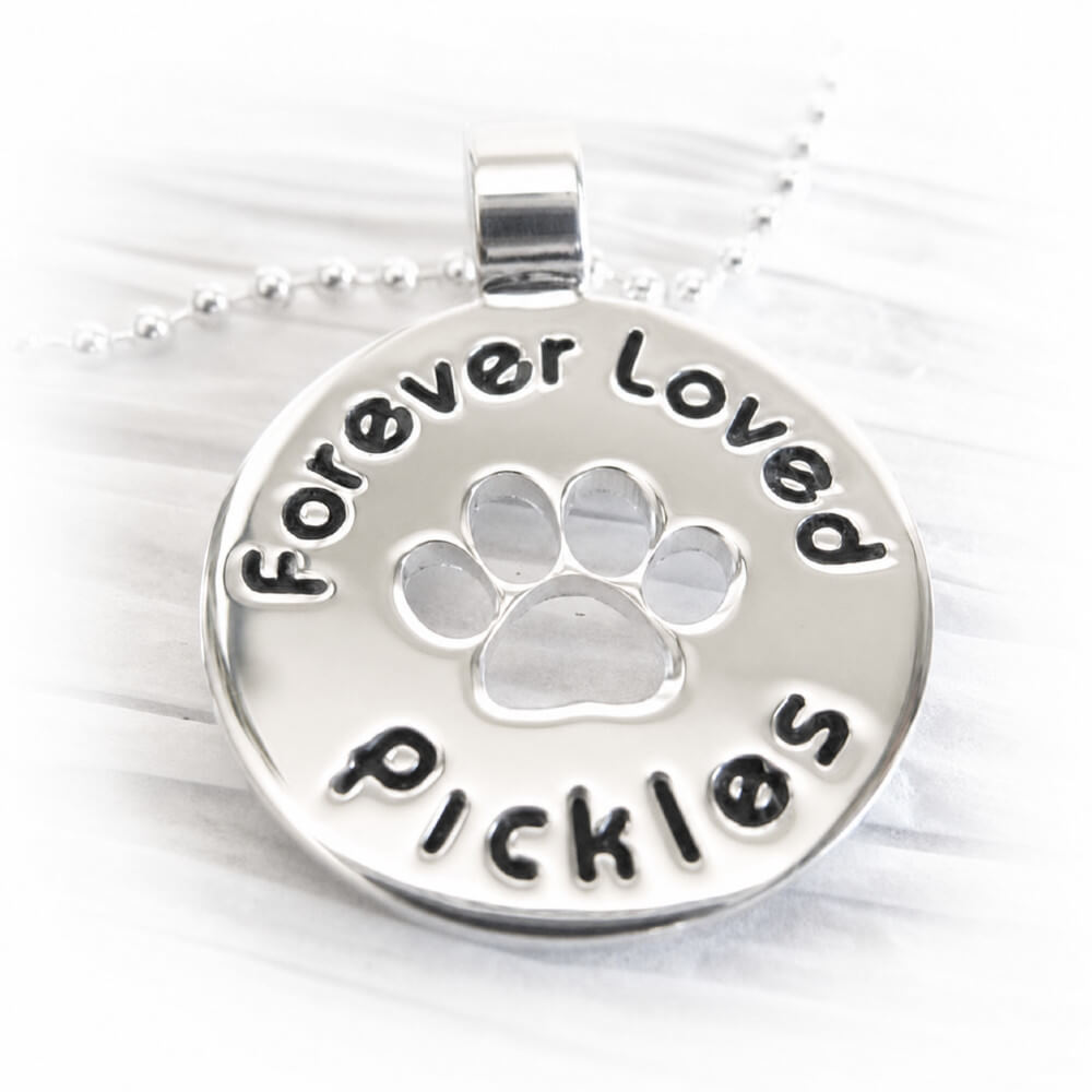 Sterling silver remembrance pendant for a lost pet with custom engraving and a paw print cutout