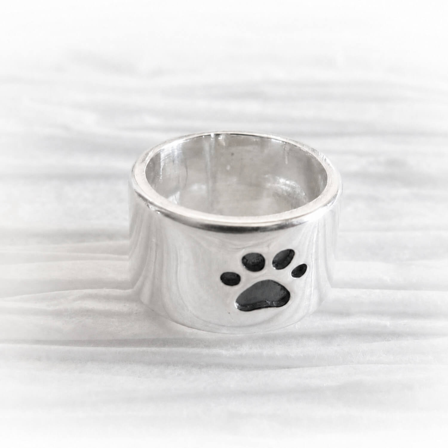 Hand forged polished sterling silver slider bead with an engraved paw print