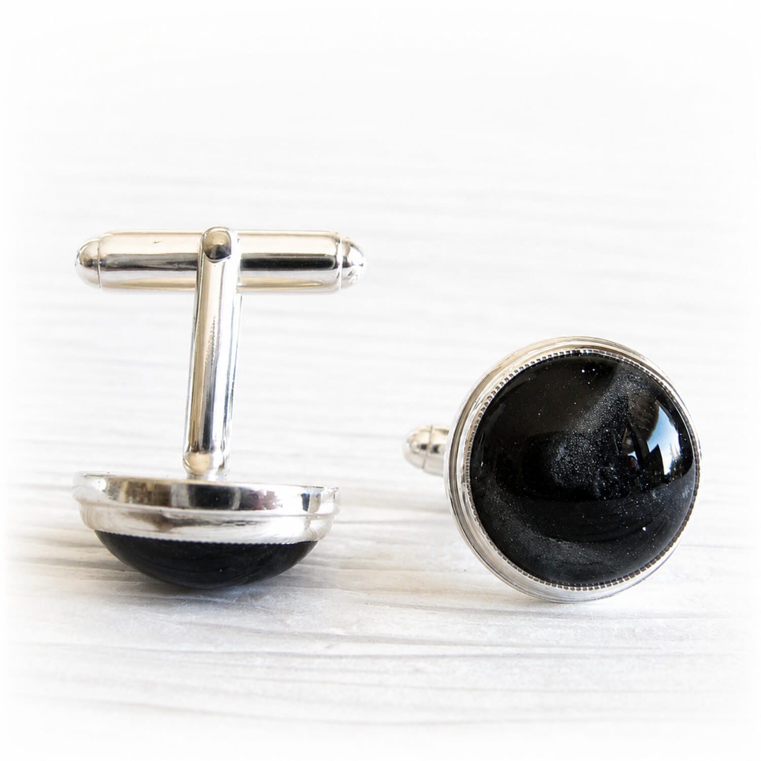 Memorial cufflinks with cremation ashes sealed within the glass