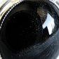 Close up of cremation ashes in a black glass cabochon set in sterling silver