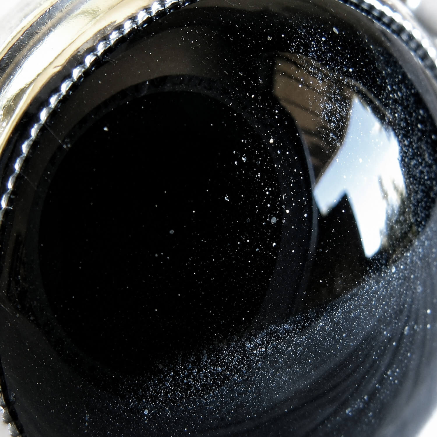 Close up of cremation ashes in a black glass cabochon set in sterling silver