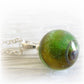 Green cremation marble swirled with pet ashes set on a sterling silver necklace
