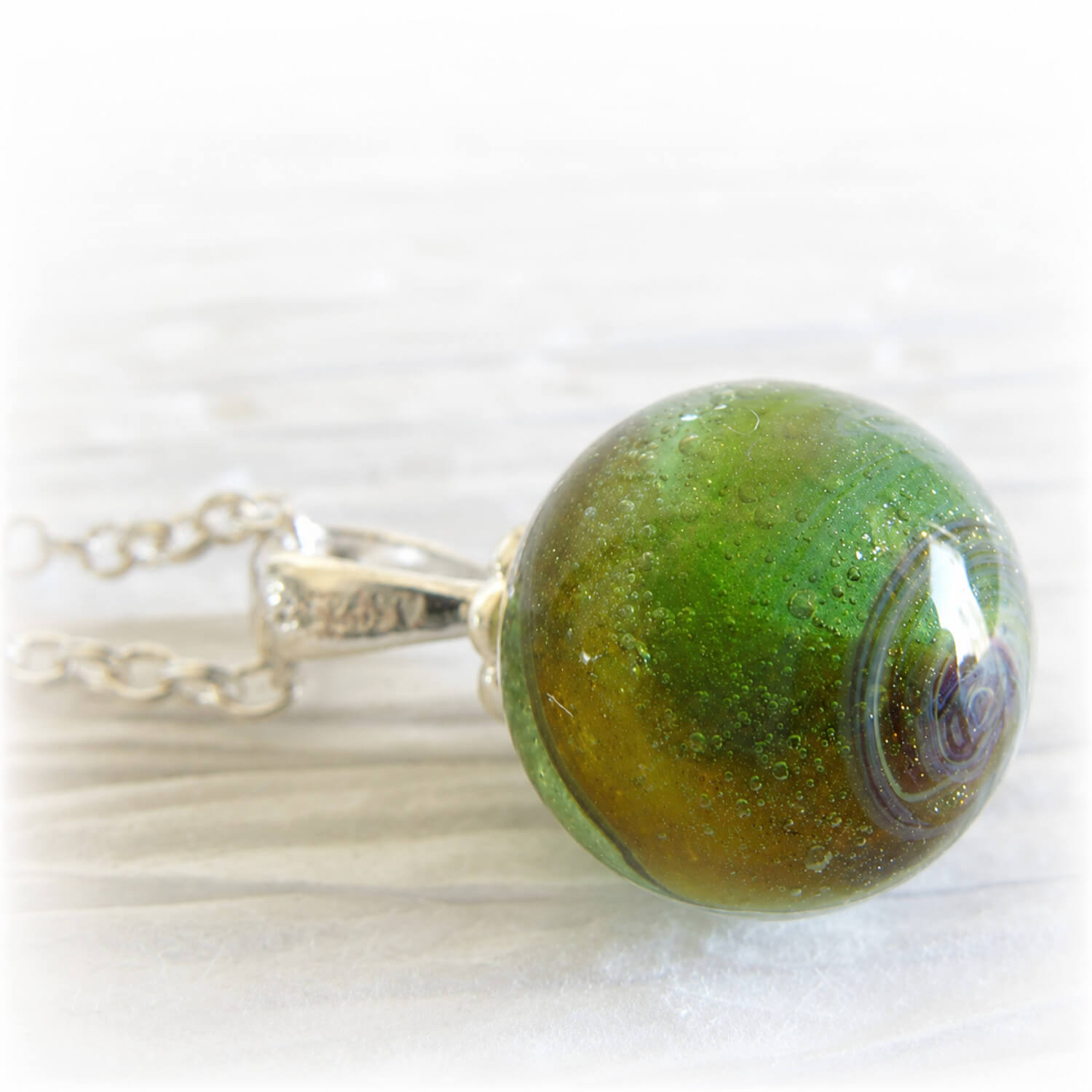 Green cremation marble swirled with pet ashes set on a sterling silver necklace