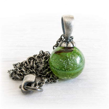 Green glass ash pendant on a sterling silver necklace with an antique finish