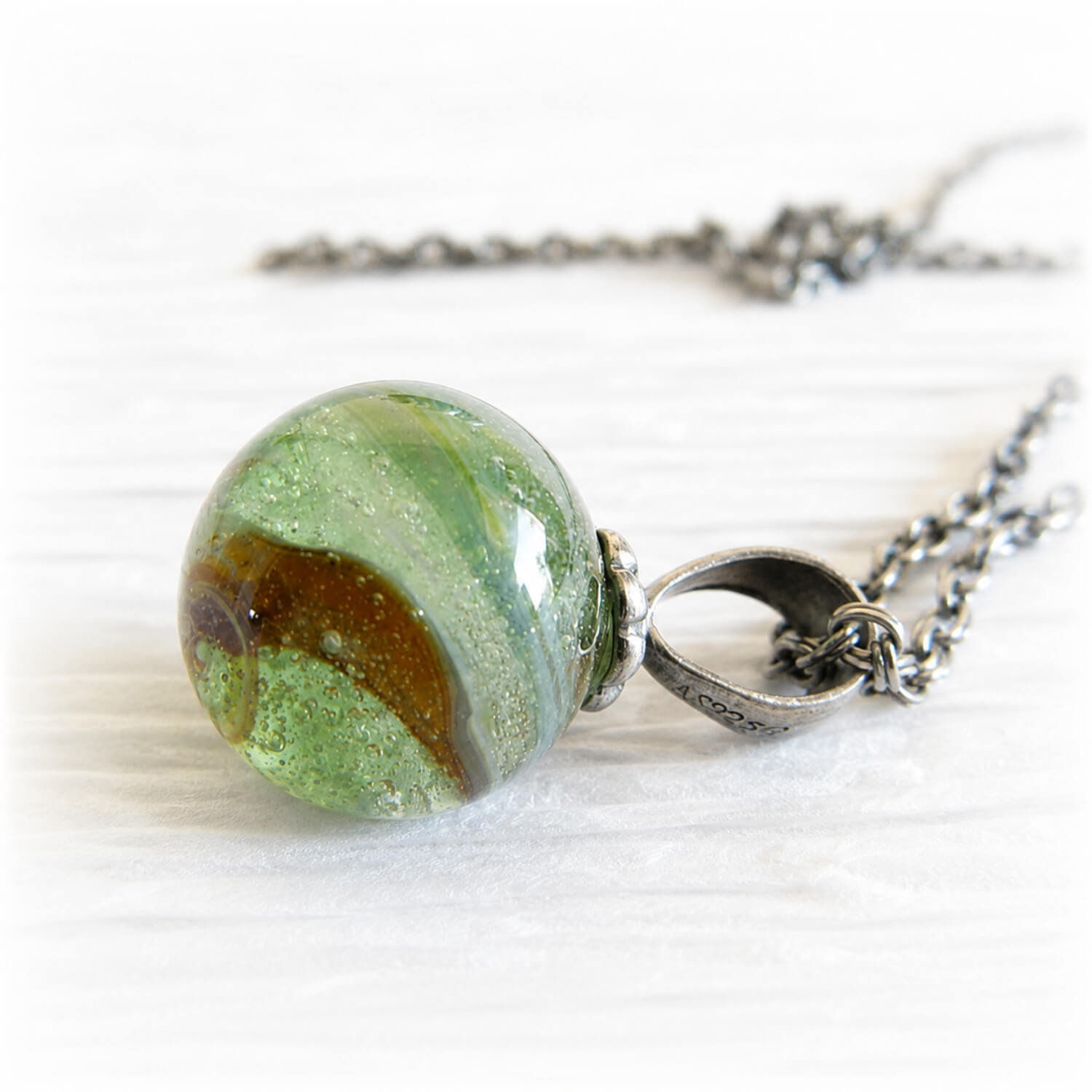 Memorial necklace with a green and brown marbled glass pendant set on sterling silver with an antique finish
