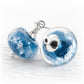 Round blue galaxy cremation glass earrings accented with polished silver decorative bead caps