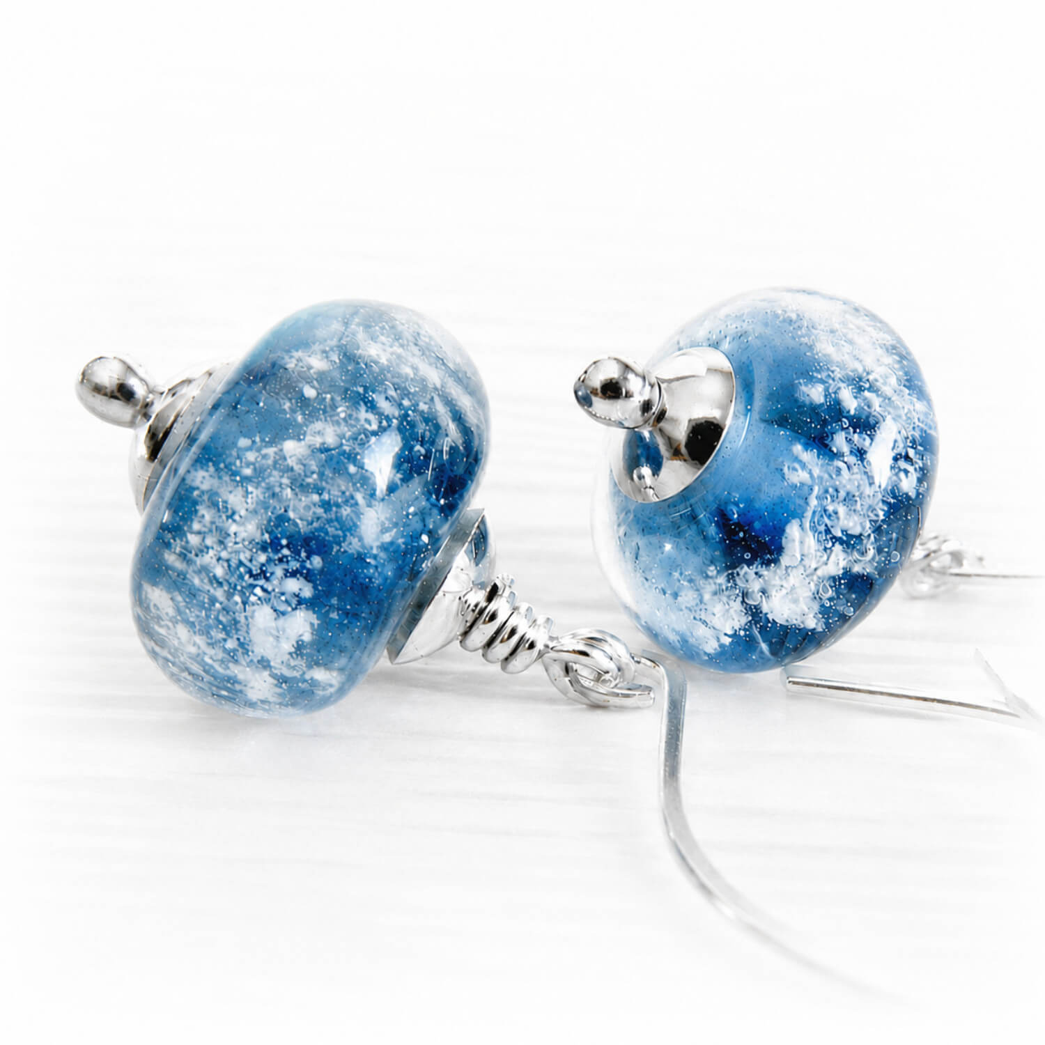 Blue glass cremation ash dangle earrings with silver bead caps on elegant drop hooks
