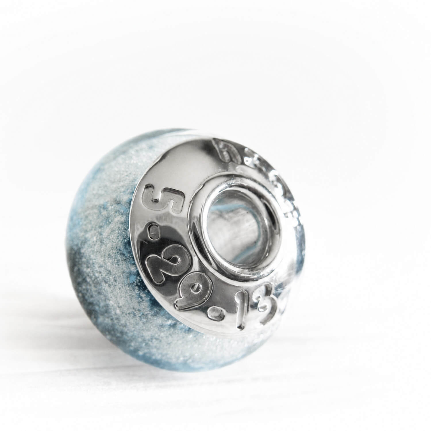 Custom engraved sterling silver beads caps on a blue hand blown glass memorial bead