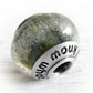 Green and blue glass bead encased  with floating cremation ashes 