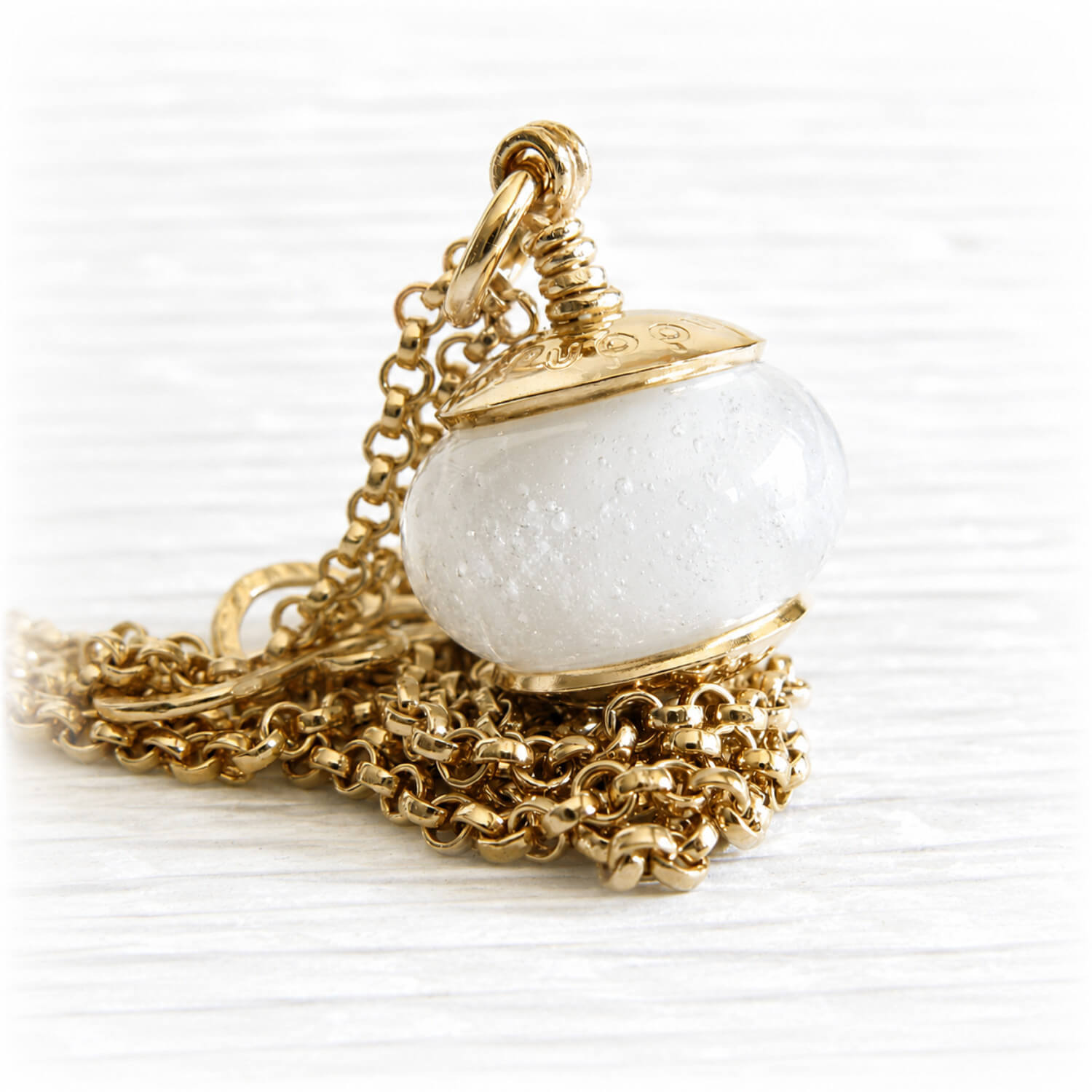 14k gold memorial pendant necklace with a round white glass ash bead cradled in a polished gold cup setting