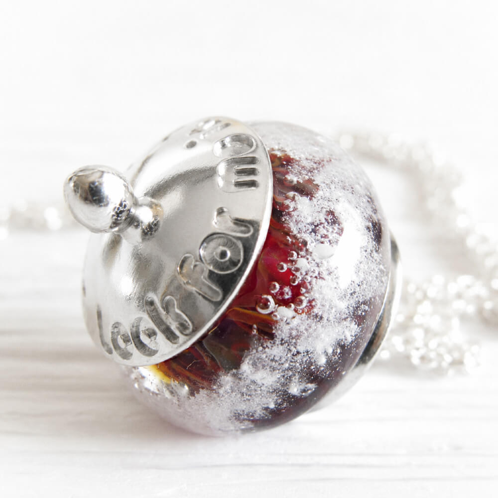 Deep red lamp-work cremation bead with encased ashes set in a sterling silver pendant