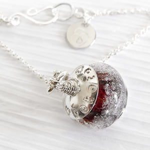 Artisan crafted cremation necklace with custom engraving on a white background