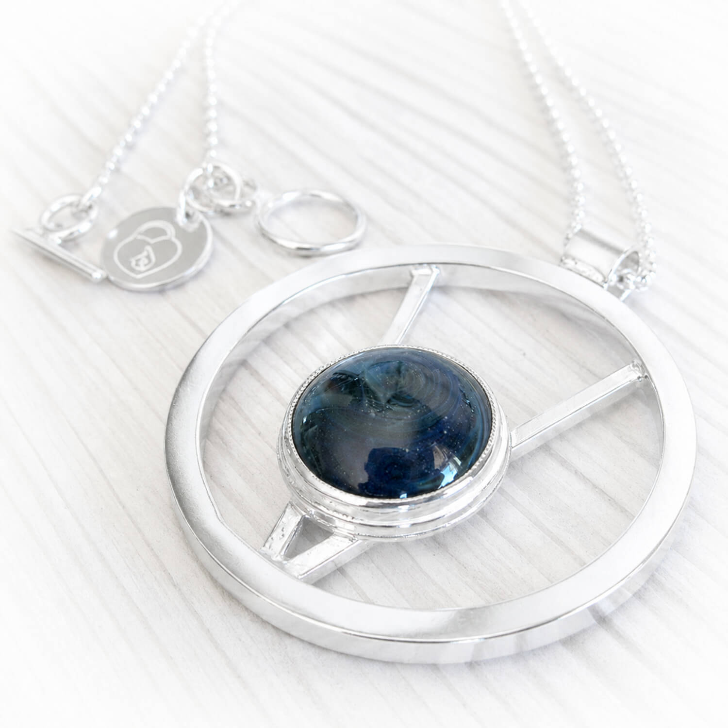 Sterling silver memorial necklace forged by hand from sterling silver with blue hand blown glass encasing cremation ashes