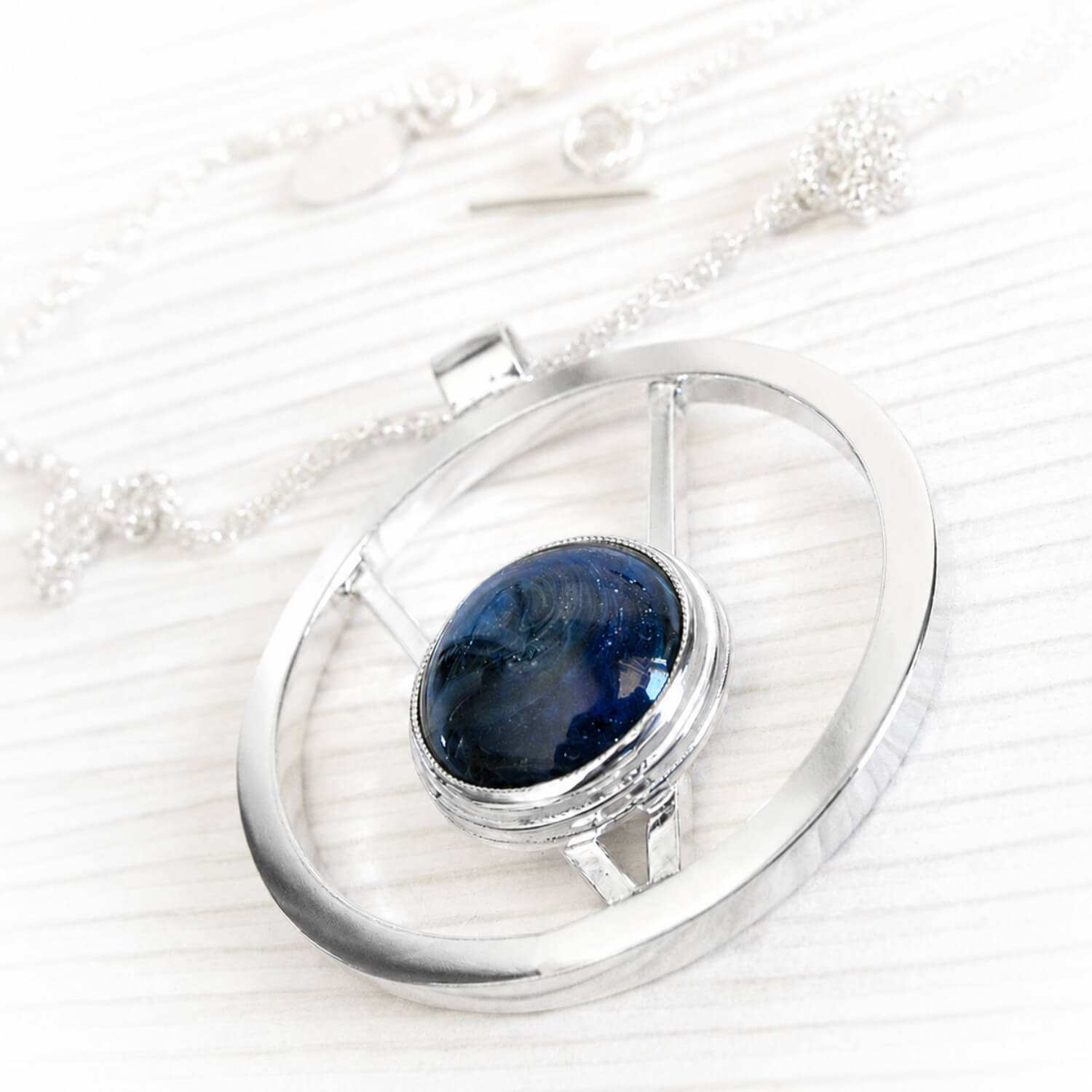Solid sterling silver memorial pendant with swirled blue glass handcrafted with cremation ashes
