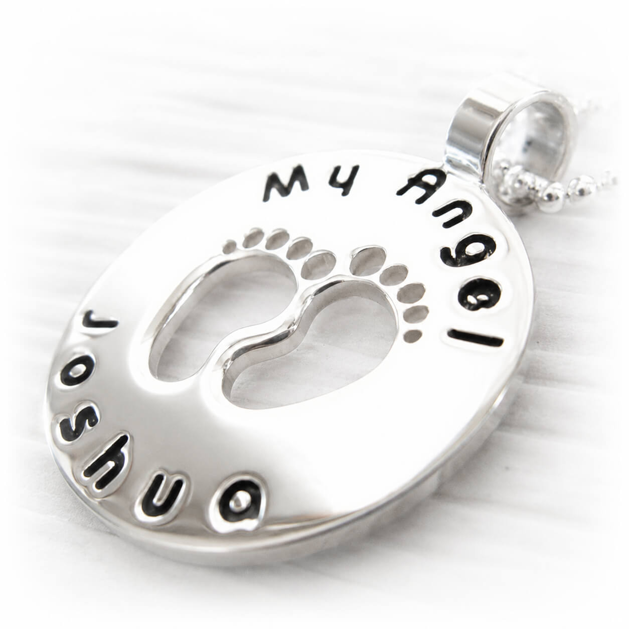 Sterling silver pendant with footprints and engraved with custom text on a silver bead chain