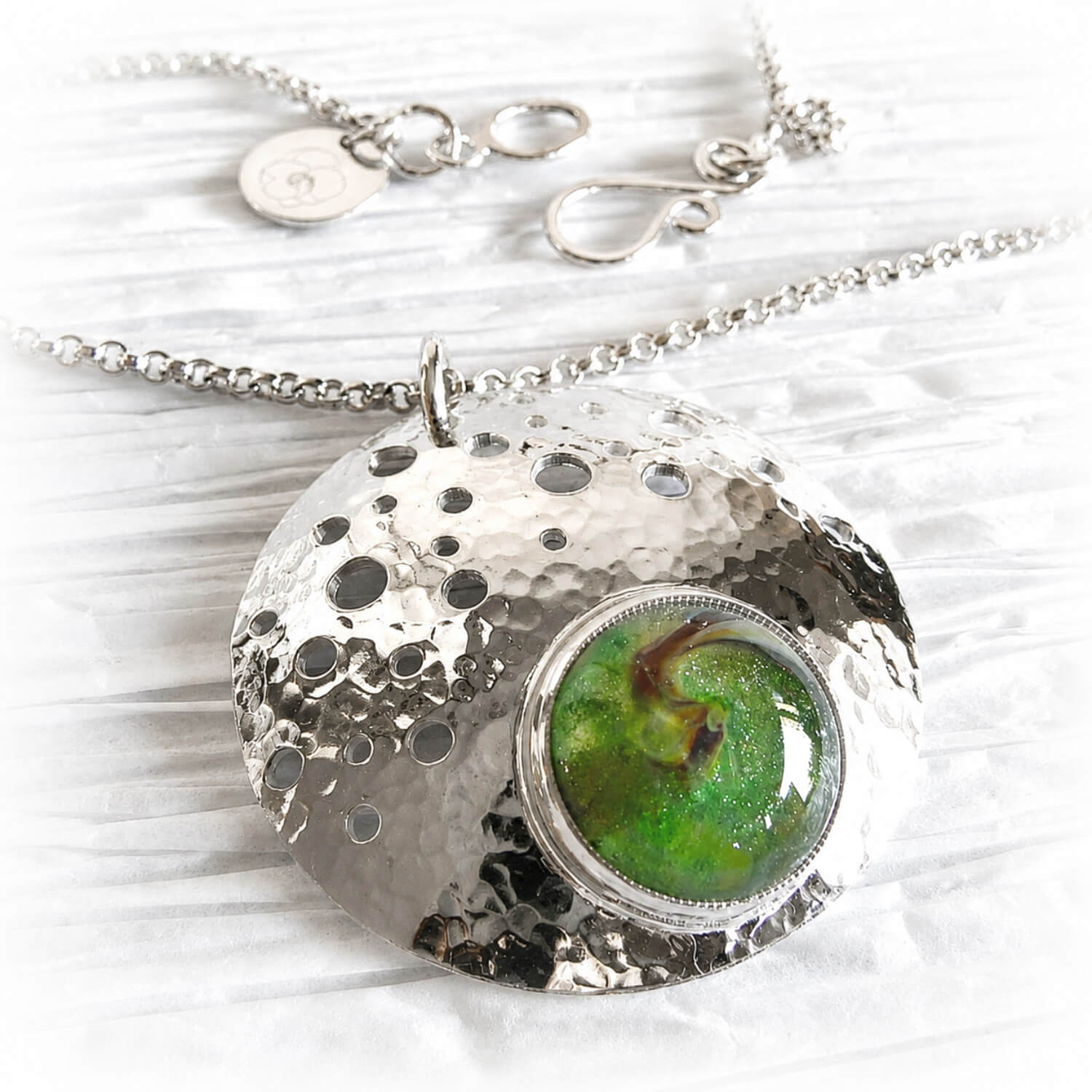 Artisan forged sterling silver memorial pendant with a hand blown green glass dome