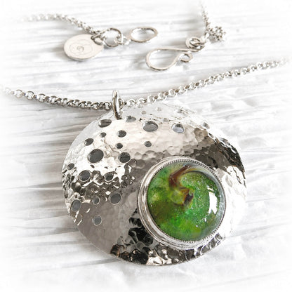 Artisan forged sterling silver memorial pendant with a hand blown green glass dome
