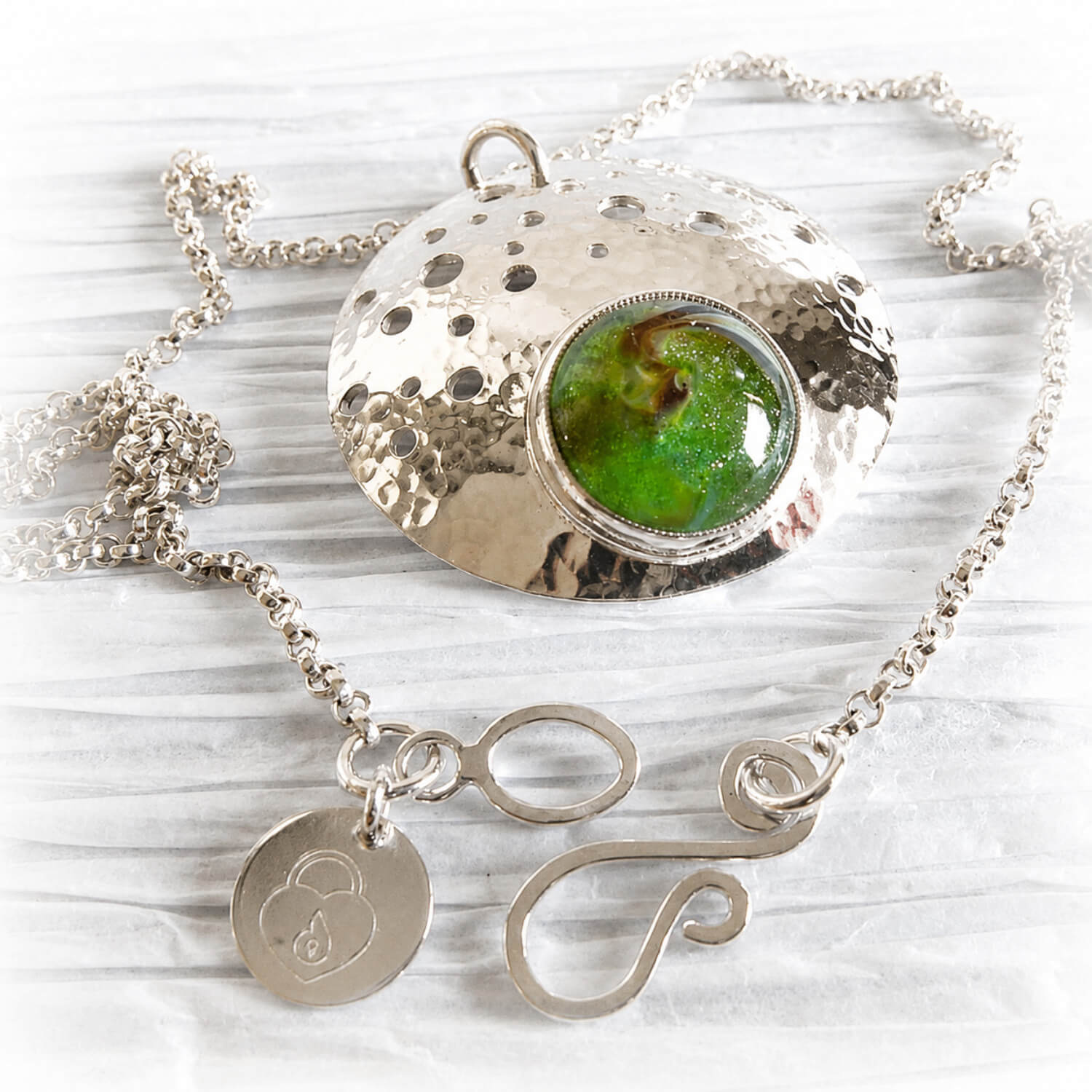 Sterling silver memorial necklace with cremation ashes permanently encased in green glass